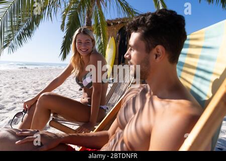 Couple caucasien assis sur des chaises longues à la plage Banque D'Images