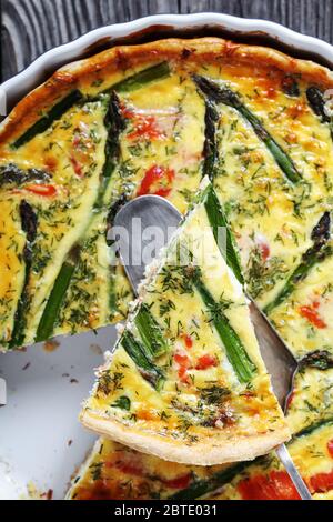 gros plan de quiche avec garniture de fromage d'asperges de saumon coupée en tranches dans un plat de cuisson sur une ancienne table en bois, vue horizontale depuis le dessus, plat Banque D'Images