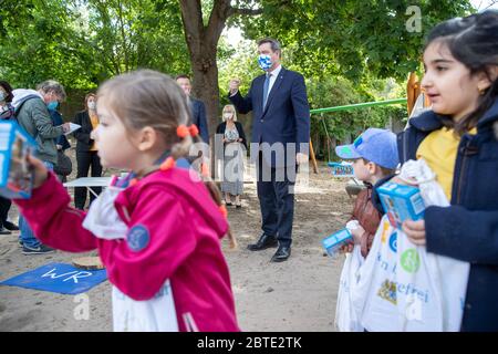 Nuremberg, Allemagne. 25 mai 2020. Markus Söder (CSU, M), ministre-président de Bavière, porte un masque lors d'une visite à un jardin d'enfants de Nuremberg. Debout devant lui sont des enfants, chacun tenant un cadeau de bienvenue dans ses mains pour les accueillir de nouveau à la maternelle. Depuis le 25 mai, les enfants de Bavière ont été autorisés à aller à nouveau à la maternelle. Crédit : Daniel Karmann/dpa/Alay Live News Banque D'Images