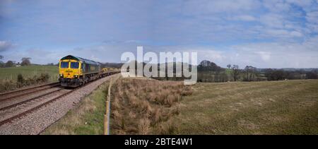 Freightliner classe 66 locomotive 66596 passant par Borwick sur la pittoresque petite ligne de chemin de fer du nord-ouest rural avec un train de génie Banque D'Images