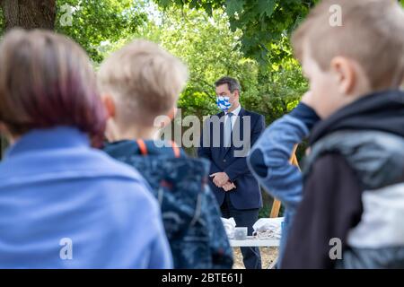 Nuremberg, Allemagne. 25 mai 2020. Markus Söder (M., CSU), Premier ministre de Bavière, se tient devant les enfants portant un masque lors d'une visite à un jardin d'enfants de Nuremberg. Depuis le 25 mai, les enfants de Bavière ont été autorisés à aller à nouveau à la maternelle. Crédit : Daniel Karmann/dpa/Alay Live News Banque D'Images