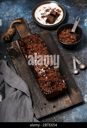 Délicieux gâteau au chocolat maison avec garniture aux chips et glaçage sur du pain rustique coupé en bois. Mise au point sélective. Banque D'Images