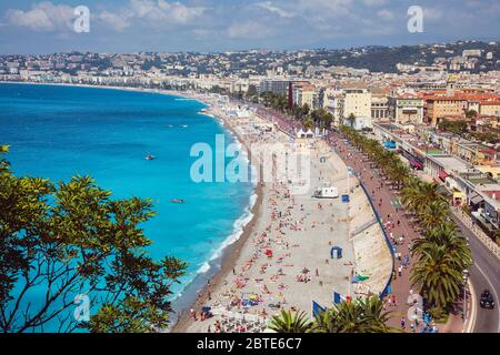 Nice, Côte d'Azur, France. Baigneurs sur la plage en face de la Promenade des Anglais. Vue depuis le Parc de la Colline du Château. Banque D'Images