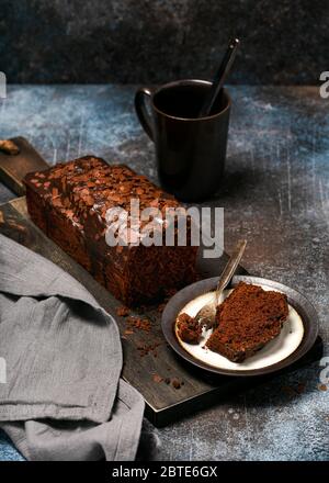 Assiette avec une tranche de délicieux gâteau au chocolat maison sur fond rustique. Photographie de nourriture sombre. Mise au point sélective. Banque D'Images