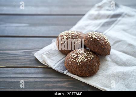 Pain au keto. Délicieux pains cétogènes à la farine d'amandes, faits maison avec de la croûte et des graines de sésame sur un panneau de bois Banque D'Images