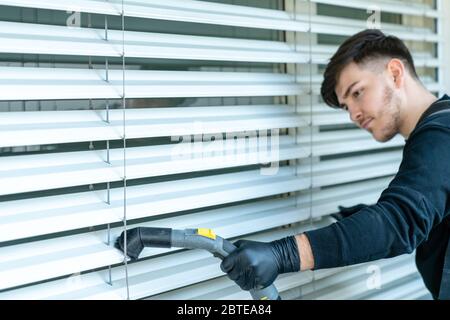 aspirateur professionnel stores de fenêtre sur un balcon d'appartement dans un bâtiment de haute hauteur Banque D'Images