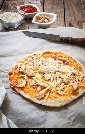 préparation de la masse de pizza avec de la farine sur une table en bois Banque D'Images