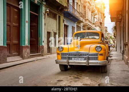 Voiture jaune américaine classique dans la rue, la Vieille ville de la Havane, la Habana Vieja, Cuba, UNESCO Banque D'Images