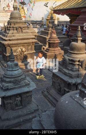 Un garçon népalais se promène entre les petites chaïas près du grand stupa de Swayambhunath à Katmandou, dans la vallée de Katmandou, au Népal Banque D'Images