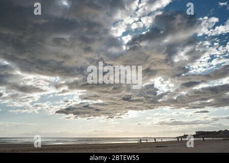 Image à l'horizon bas de la plage de Carcavellos par Lisbonne, Portugal, avec des nuages bas et peu de personnes à la plage Banque D'Images