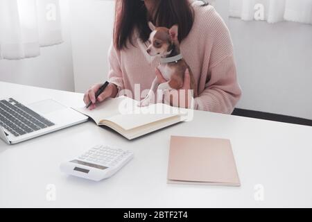 Yong femme travaillant à domicile pendant qu'elle est en quarantaine pendant la pandémie Covid-19. Banque D'Images