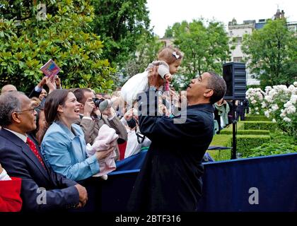 Le président Barack Obama lève un bébé tout en respectant le personnel de l'Ambassade américaine après son arrivée à la résidence de l'ambassadeur à Caen, France, 6 juin 2009. Banque D'Images