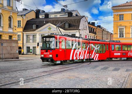 Déplacement du tramway HSL avec la publicité Coca-Cola et la maison de Sederholm, le plus ancien bâtiment dans le centre-ville, en arrière-plan. Helsinki, Finlande. 25 mai 2020. Banque D'Images