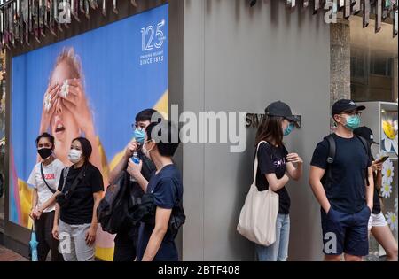 Les manifestants se tiennent dans les rues de Causeway Bay tout en portant un masque facial comme mesure préventive pendant la manifestation. Des violences, des arrestations et l'utilisation de canons à eau sont retournés dans les rues de Hong Kong avec des centaines de manifestants marchant sur l'île de Hong Kong contre le projet de la Chine d'imposer une loi de sécurité nationale. Banque D'Images