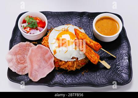 Nasi goreng, littéralement du riz frit en indonésien, servir avec du poulet, des crevettes etc Banque D'Images
