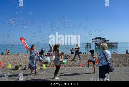 Brighton UK 25 mai 2020 - UN amuseur à bulles dans la fin de l'après-midi soleil sur la plage et le front de mer de Brighton que le week-end de vacances de banque attire à une fin aujourd'hui sur la côte sud pendant la crise pandémique de coronavirus COVID-19 . Crédit : Simon Dack / Alamy Live News Banque D'Images