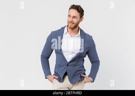 Image d'un jeune homme joyeux portant une veste souriante et regardant de côté isolé sur fond blanc Banque D'Images