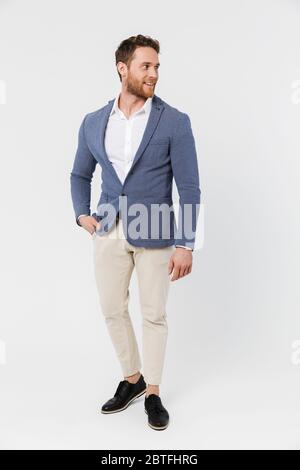 Image d'un jeune homme joyeux portant une veste souriante et regardant de côté isolé sur fond blanc Banque D'Images