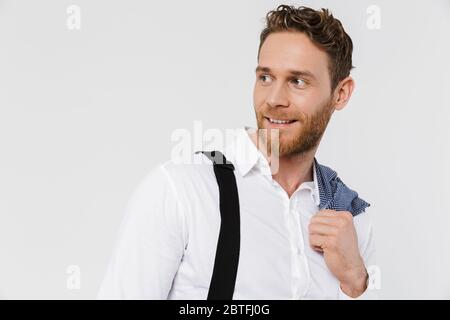 Image d'un homme blond souriant tenant une veste et regardant de côté isolé sur fond blanc Banque D'Images