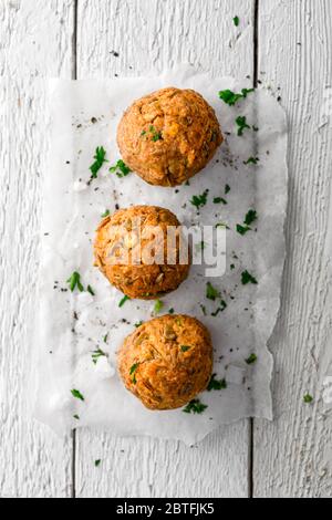 Boulettes de viande vegan Lentil sur papier de cuisson sur surface en bois blanc Banque D'Images