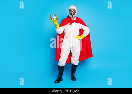 Concept de service de désinfection Ncov de meilleure résistance. Homme médecin tenir couronne dorée porter costume blanc jaune lunettes latex gants respirateur de gaz costume rouge Banque D'Images