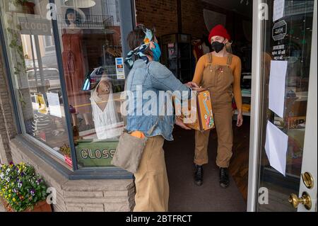 Grass Valley, Californie, États-Unis. 18 mai 2020. Caity Koppers donne à la cliente Lisa Van Tassel son achat à la porte le lundi 18 mai 2020 à Grass Valley pendant la pandémie du coronavirus. Le magasin Mint sert les clients sur rendez-vous seulement et ils sont maintenant autorisés dans le magasin. Crédit : Paul Kitagaki Jr./ZUMA Wire/Alay Live News Banque D'Images