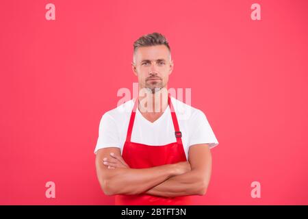 homme mature en tablier a croisé les mains. hôtesse du restaurant. Restauration rapide. Personnel du restaurant. Personnel en uniforme. Une approche professionnelle pour les affaires. Bienvenue dans notre café. Banque D'Images