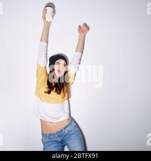 Gros plan studio de joli hipster adolescente fille avec bonnet beanie tenant la tête faisant drôle visage. Image carrée avec filtre instantané appliqué. Banque D'Images