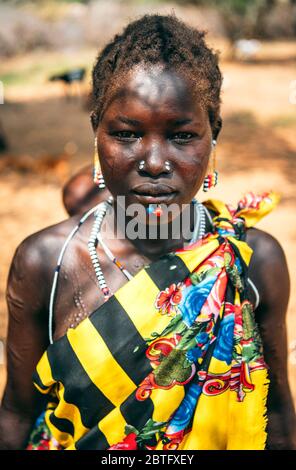 Tribu BOYA, SUD SOUDAN - 10 MARS 2020: Femme en vêtements traditionnels colorés et accessoires avec perçage rituel et modifications de cicatrice regardant Banque D'Images