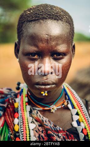 Tribu TOPOSA, SOUDAN DU SUD - 12 MARS 2020 : femme de la tribu Toposa portant des perles colorées traditionnelles et perçant et regardant la caméra dans le Sud Banque D'Images