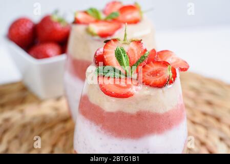 Verre de délicieux smoothie maison sucré en couches, à base de fruits et de baies. Délicieux milkshake aux bananes fraise, aliments crus végétaliens. Sélectionnez Banque D'Images