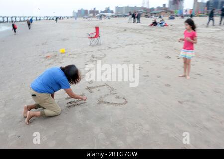 Brooklyn, NY, États-Unis. 25 mai 2020. Les New Yorkers et les amoureux de Coney Island visitent la promenade de Coney Island pour célébrer le Memorial Day, le début non officiel de l'été, où des masques faciaux gratuits ont été distribués par des membres du clergé et le NYPD, y compris le chef du NYPD Shcoll le 25 mai 2020 à Brooklyn, New York. Crédit : Mpi43/Media Punch/Alay Live News Banque D'Images