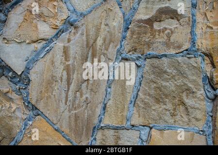 Texture de pavage de blocs de pierre marron naturel. Mur en pierre avec coutures noires. Arrière-plan du bâtiment Banque D'Images