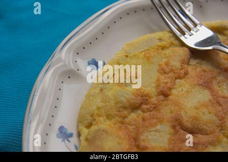 Gros plan d'une assiette avec une omelette espagnole ou une pomme de terre à côté d'une fourchette prête à manger Banque D'Images