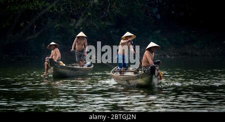 HUE - 07 MARS 2018: Des pêcheurs vietnamiens lancent un grand fachnet jaune dans la paisible rivière Song Nhu y à Hue, au Vietnam, le 07 mars 2018 Banque D'Images