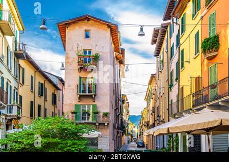 Bâtiment traditionnel coloré avec balcons, fenêtres à volets et murs multicolores dans une rue italienne typique, centre historique de Brescia, ciel bleu, Lombardie, Italie du Nord Banque D'Images