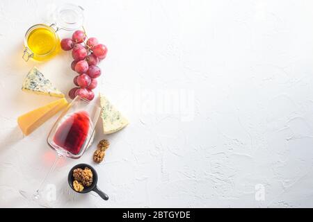 Antipasti assortiment de fromages vin rouge verre camembert dorblu parmesan bio blanc texturé pierre fond avec des rayures naturelles et s Banque D'Images
