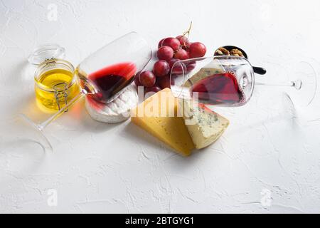 Deux verres à vin rouge avec sélection de hors-d'œuvre au fromage ou en-cas à la baleine. Variété de fromage, raisins, noix de pécan vue latérale espace pour le texte. Banque D'Images