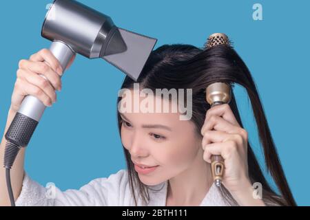 Brunette jeune femme asiatique sèche ses cheveux Banque D'Images