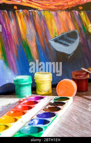 La tempera peint sur la table dans un atelier, la mise au point sélective, le jeu de peintures aquarelles, les brosses pour la peinture et la palette Banque D'Images