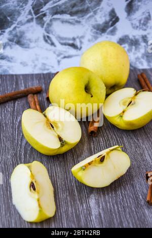 Pommes dorées vertes ou Granny smith avec des bâtons de cannelle sur fond de bois, préparation de nourriture, dessert Banque D'Images