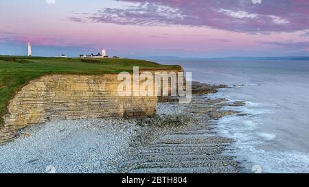 Phare de Nash point, sud du pays de Galles, au coucher du soleil. Le phare est situé au sommet de falaises abruptes, surplombant le canal de Bristol Banque D'Images