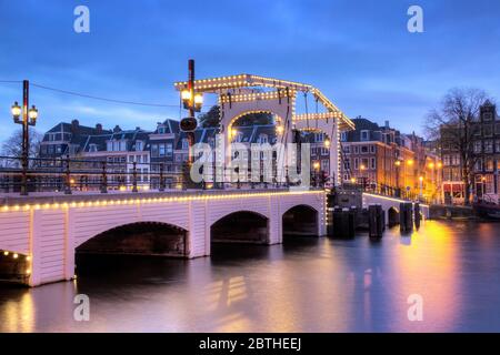 Amstel River Cityscape avec le célèbre pont skinny à Amsterdam, aux pays-Bas, tôt le matin en hiver Banque D'Images