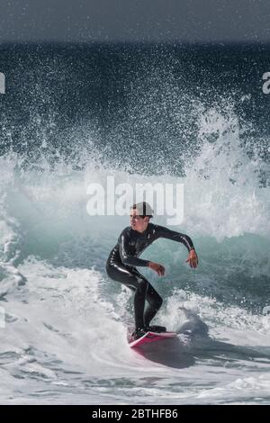 Une action spectaculaire en tant que jeune surfeur fait une vague à Fistral à Newquay, en Cornouailles. Banque D'Images