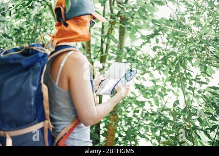 Femme consultant une carte papier et téléphone mobile pendant la randonnée. Banque D'Images