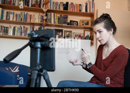 Les enseignants sont obligés d'enseigner leurs leçons à la maison en ligne virtuellement en utilisant leurs téléphones pour se filmer sous le coronavirus Covid-19 Royaume-Uni USA Banque D'Images