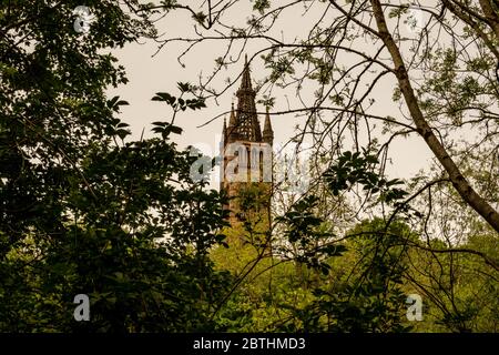 En regardant à travers les arbres du parc Kelvingrove jusqu'à la tour du bâtiment principal de l'Université de Glasgow, l'édifice Gilbert Scott dans le West End. Banque D'Images