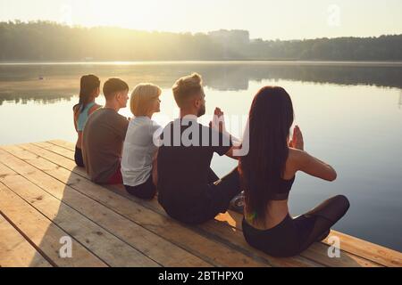 Groupe de personnes reposant vous détendre dans le parc au bord du lac Banque D'Images