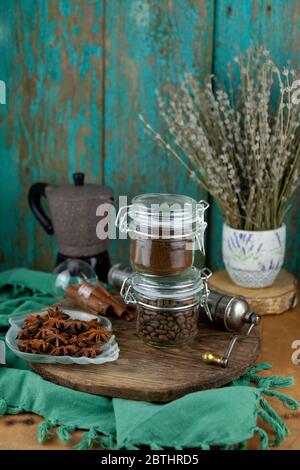 Café moulu et haricots. Petit déjeuner sur une table en bois. Tasse, pots en verre, cafetière. Encore la vie avec une boisson. Banque D'Images
