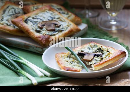 Choux au fromage, aux épinards et aux champignons, servis avec du vin et des oignons verts. Style rustique. Banque D'Images